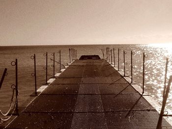 Boardwalk against sky during sunset