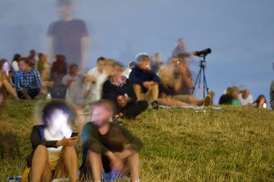 Group of people relaxing on field