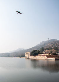 View of building by lake against sky