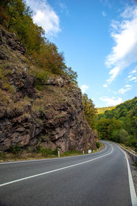 Road amidst trees against sky