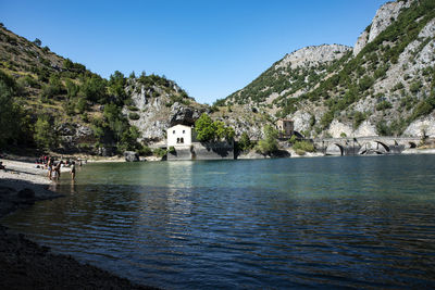 Scenic view of sea by buildings against clear blue sky