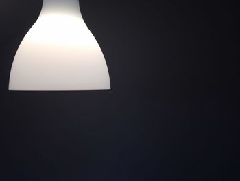 Close-up of illuminated lamp over black background