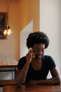 Portrait of smiling young woman sitting on table