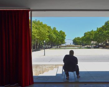 Rear view of woman standing by tree