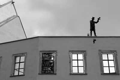 Low angle view of man standing against window
