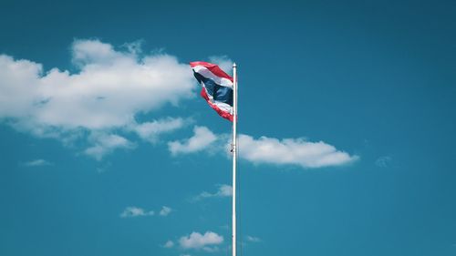 Low angle view of flag against blue sky