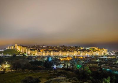 High angle view of illuminated buildings against sky at night