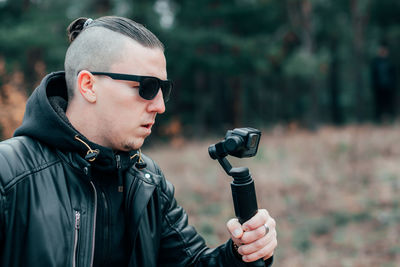 Young man filming with video camera