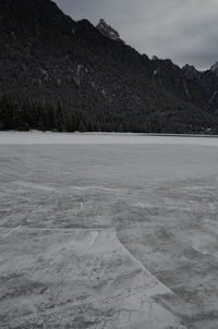 Scenic view of lake by snow mountains against sky