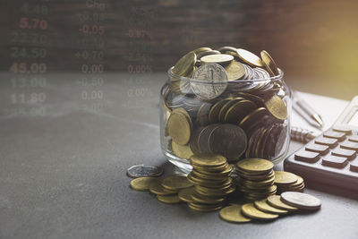 Double exposure of financial figures and coins on table