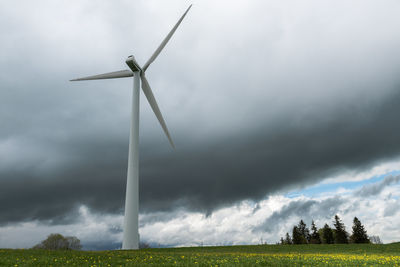 Windmills on field against sky