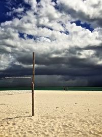 Scenic view of beach against cloudy sky