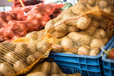 High angle view of potatoes and onions in crates at market stall