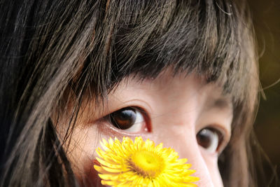 Close-up portrait of woman with yellow flower