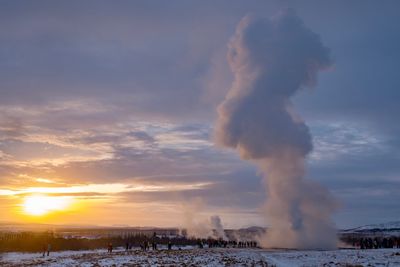 Panoramic view of people at stokkur geysir during sunset