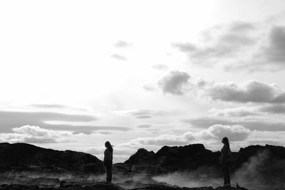 Silhouette man standing on mountain against sky