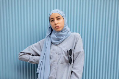 Portrait of teenage girl standing against wall