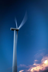 Low angle view of windmill against blue sky