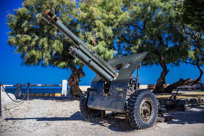 Abandoned truck on field against clear blue sky