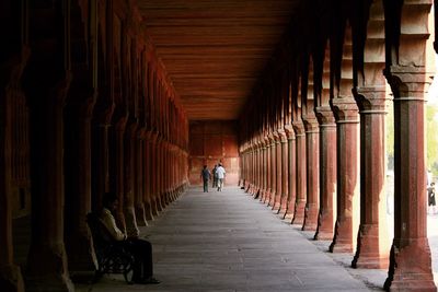 Rear view of man walking in corridor of building