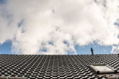 Low angle view of roof of building against cloudy sky