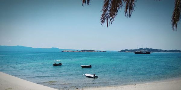 Boats moored on sea against clear sky