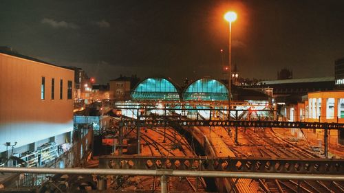 Illuminated bridge over river in city at night