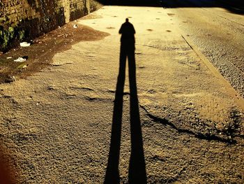 Shadow of man on sand at beach