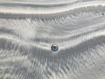 Full frame shot of glass lens  ball on beach