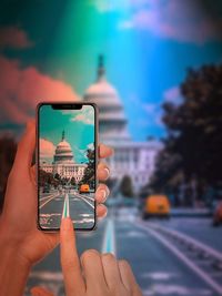 Close-up of person using mobile phone in city