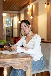 Young woman using laptop while sitting on table at home