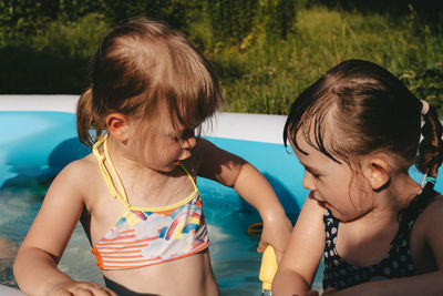 Happy children playing in the pool. friends spend summer leisure together on a hot day