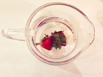 High angle view of strawberries in glass jar on table