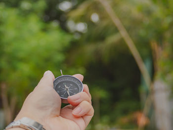 Close-up of cropped hand holding navigational compass