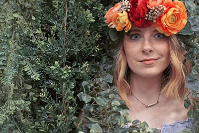 Portrait of a beautiful young woman with red flower