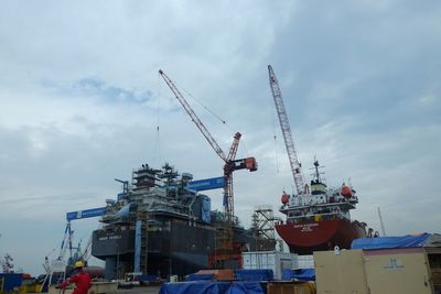 Low angle view of cranes against sky