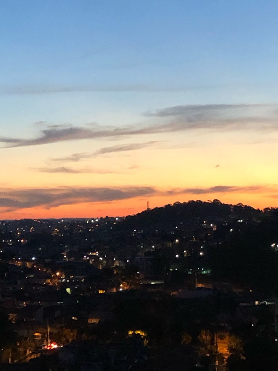 HIGH ANGLE VIEW OF ILLUMINATED BUILDINGS AT SUNSET