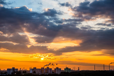 View of city against cloudy sky during sunset