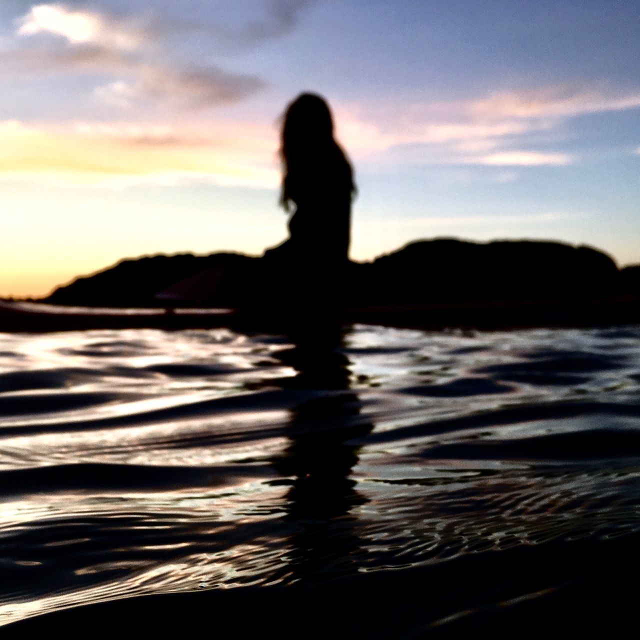 SILHOUETTE WOMAN STANDING ON SEA AGAINST SKY DURING SUNSET