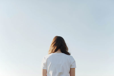 Rear view of woman standing against clear sky