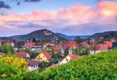 Houses in town against sky during sunset