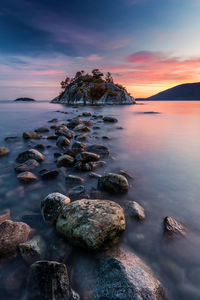 Rock hopping at high tide during sunset at whytecliff park, west vancouver , canada.