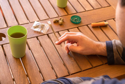Cropped image of man using mobile phone on table