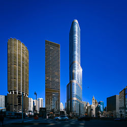 Modern buildings in city against clear blue sky