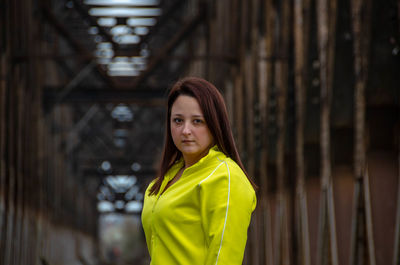 Portrait of woman standing against yellow wall