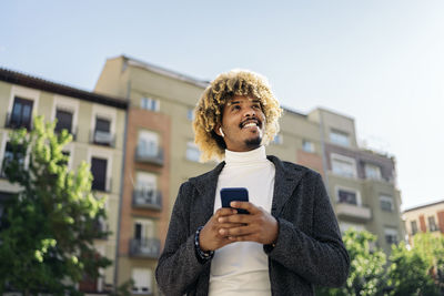 Full length of young man using smart phone