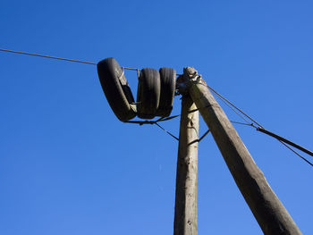 Low angle view of power lines against clear blue sky