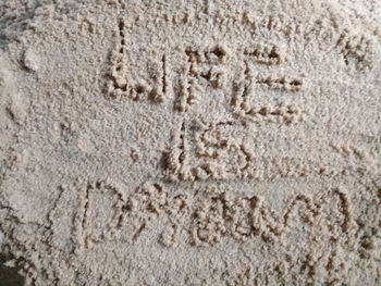 High angle view of text on sand