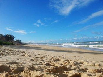 Scenic view of beach against cloudy sky