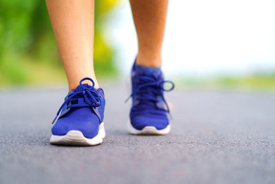 Low section of woman jogging on road